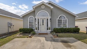 A two-story house with a front entrance, a garage door, and a driveway.