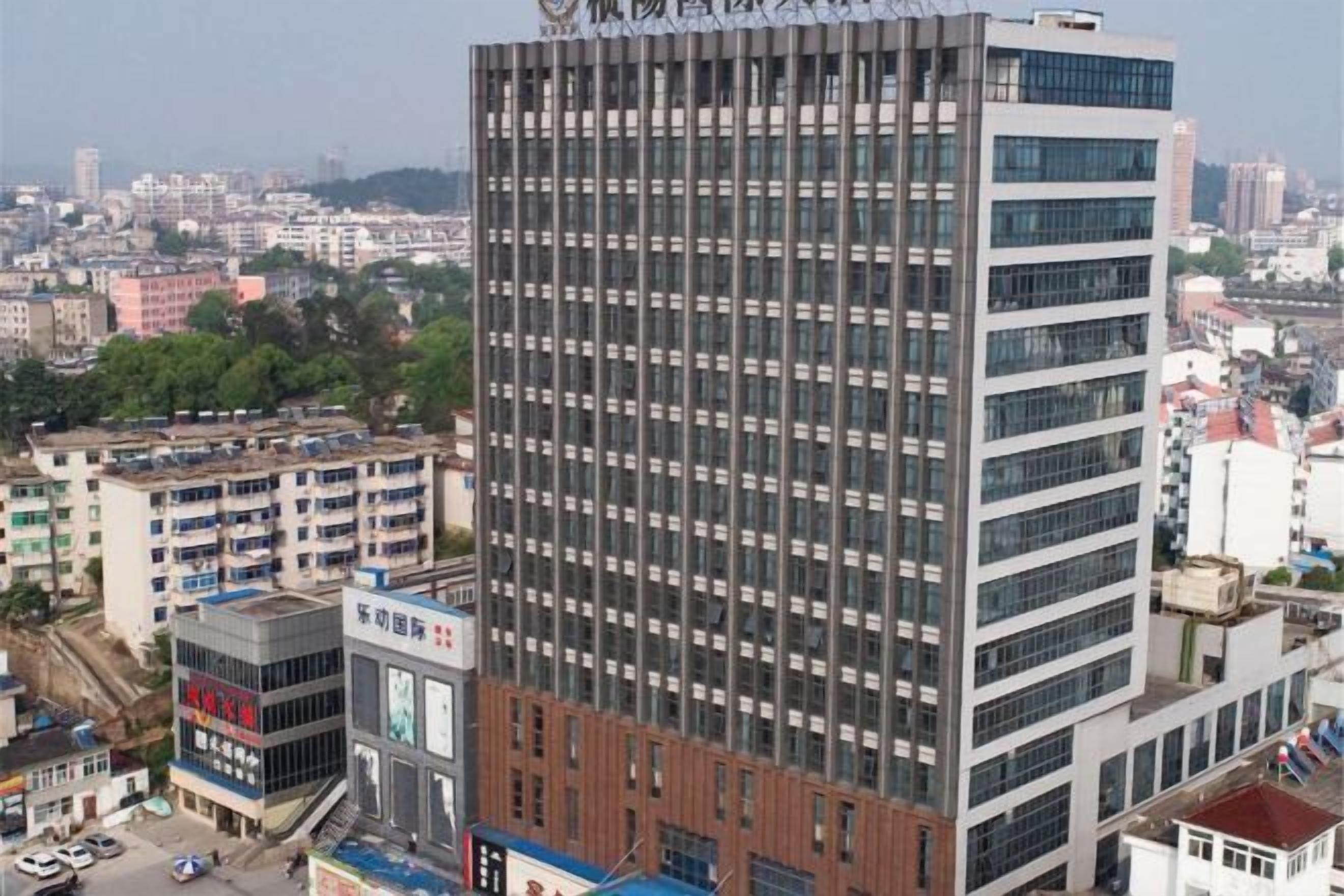 Un edificio de gran altura con un diseño arquitectónico moderno, que presenta una cuadrícula de ventanas y una fachada de vidrio y concreto.