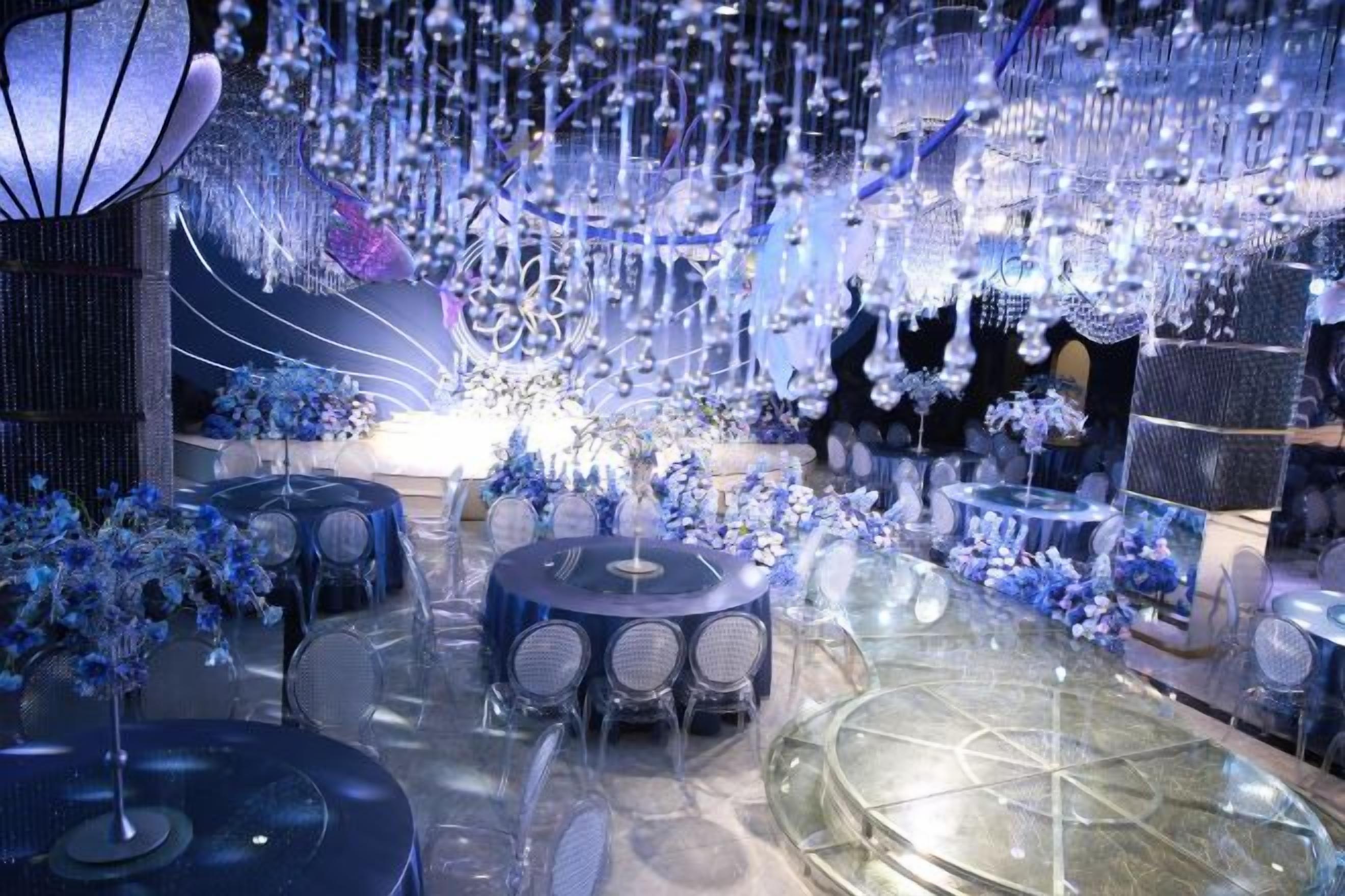 A luxurious indoor setting with round tables, chairs, and a glass ceiling.