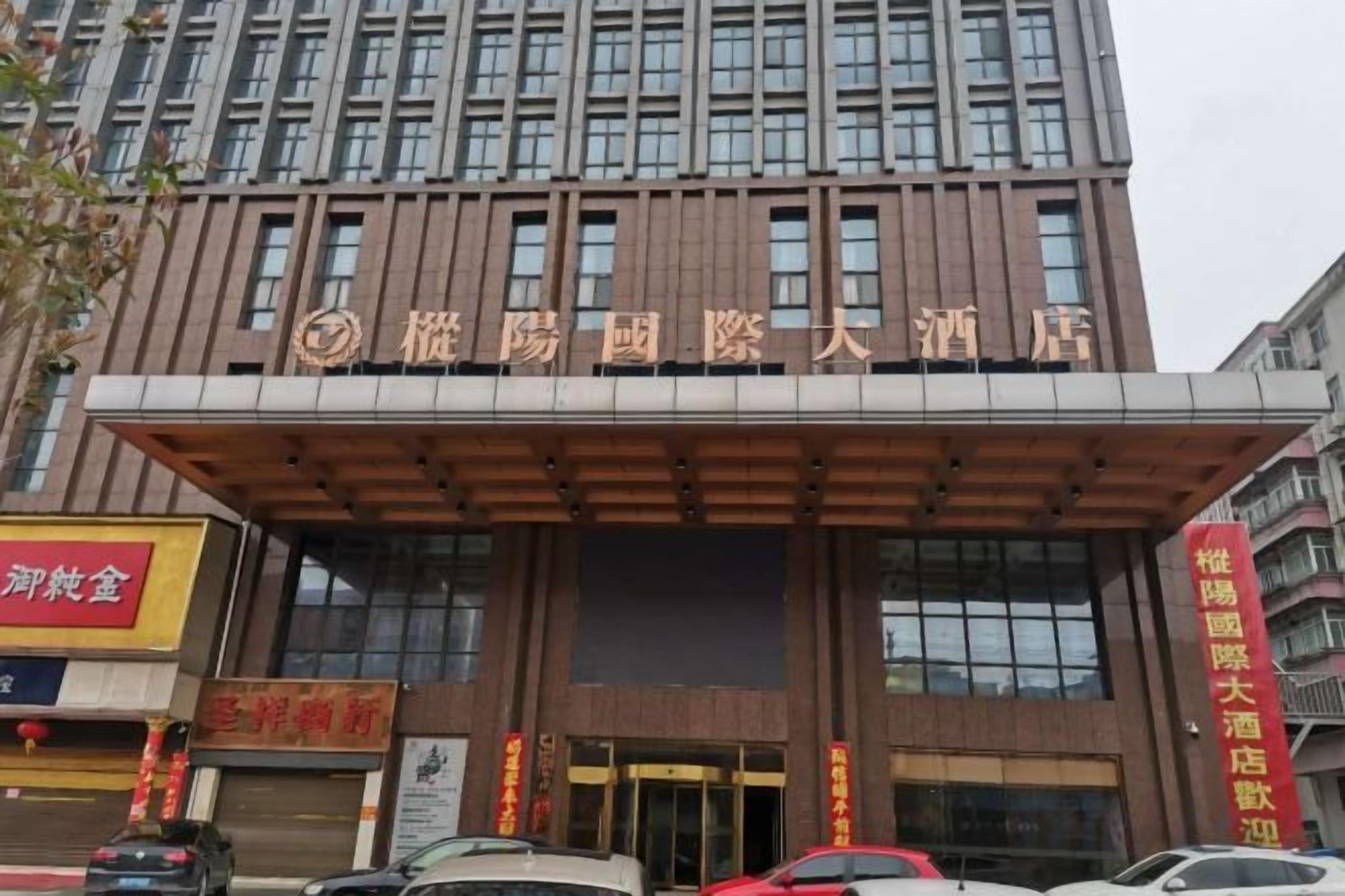 A hotel with a modern facade, large entrance doors, and signage indicating it is a hotel.