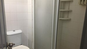 A small, enclosed bathroom with a toilet, a shower stall, and a toilet paper holder. - OTEL374 (Bolu)