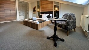 A modern bedroom with a bed, a small table, a chair, and a wardrobe. - OTEL374 (Bolu)