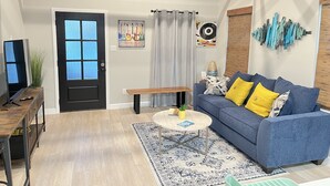 Un soggiorno con divano blu, tavolino in legno e tappeto decorato.