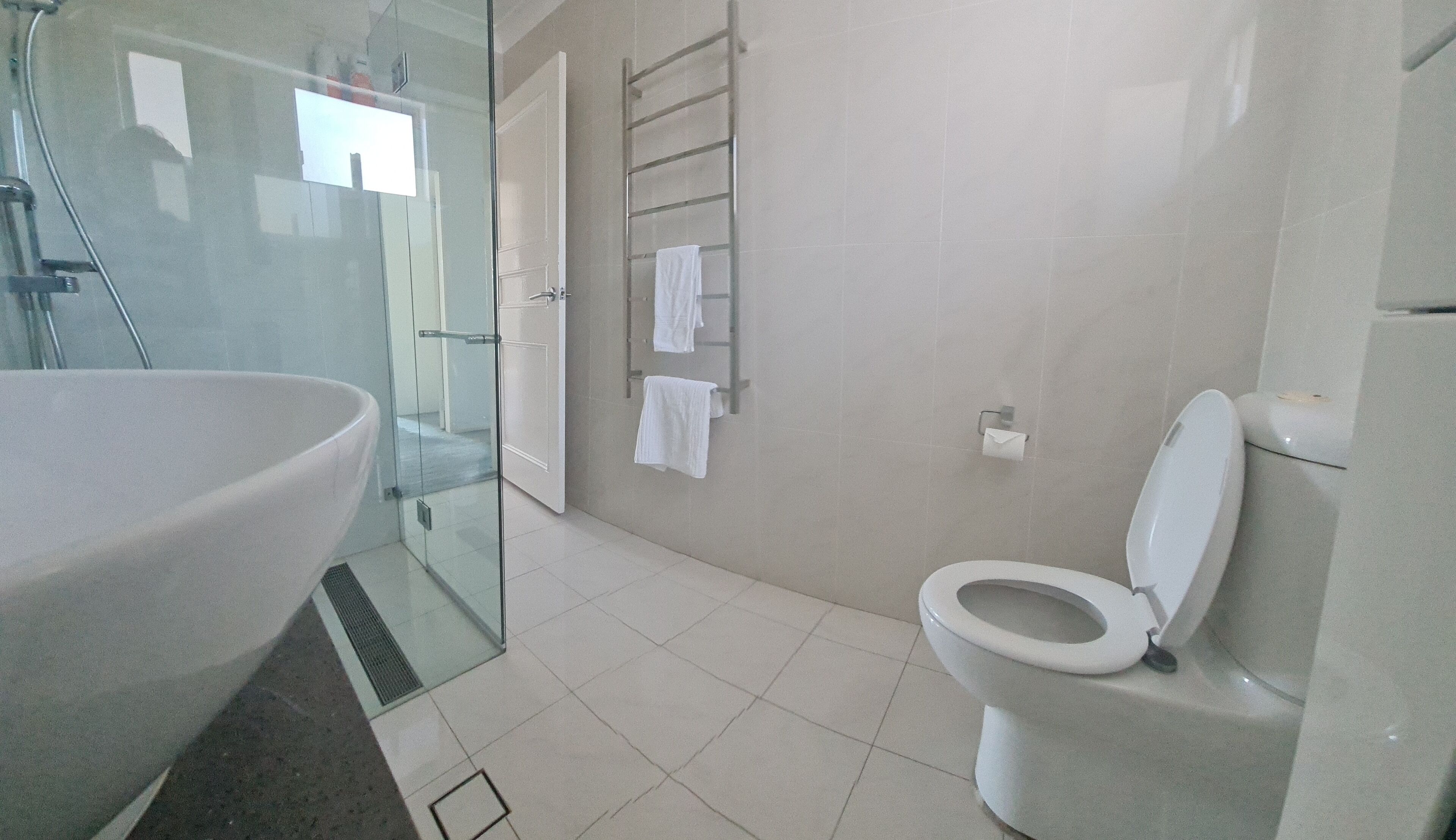 Un bagno con una vasca da bagno ampia, una cabina doccia in vetro e un water.
