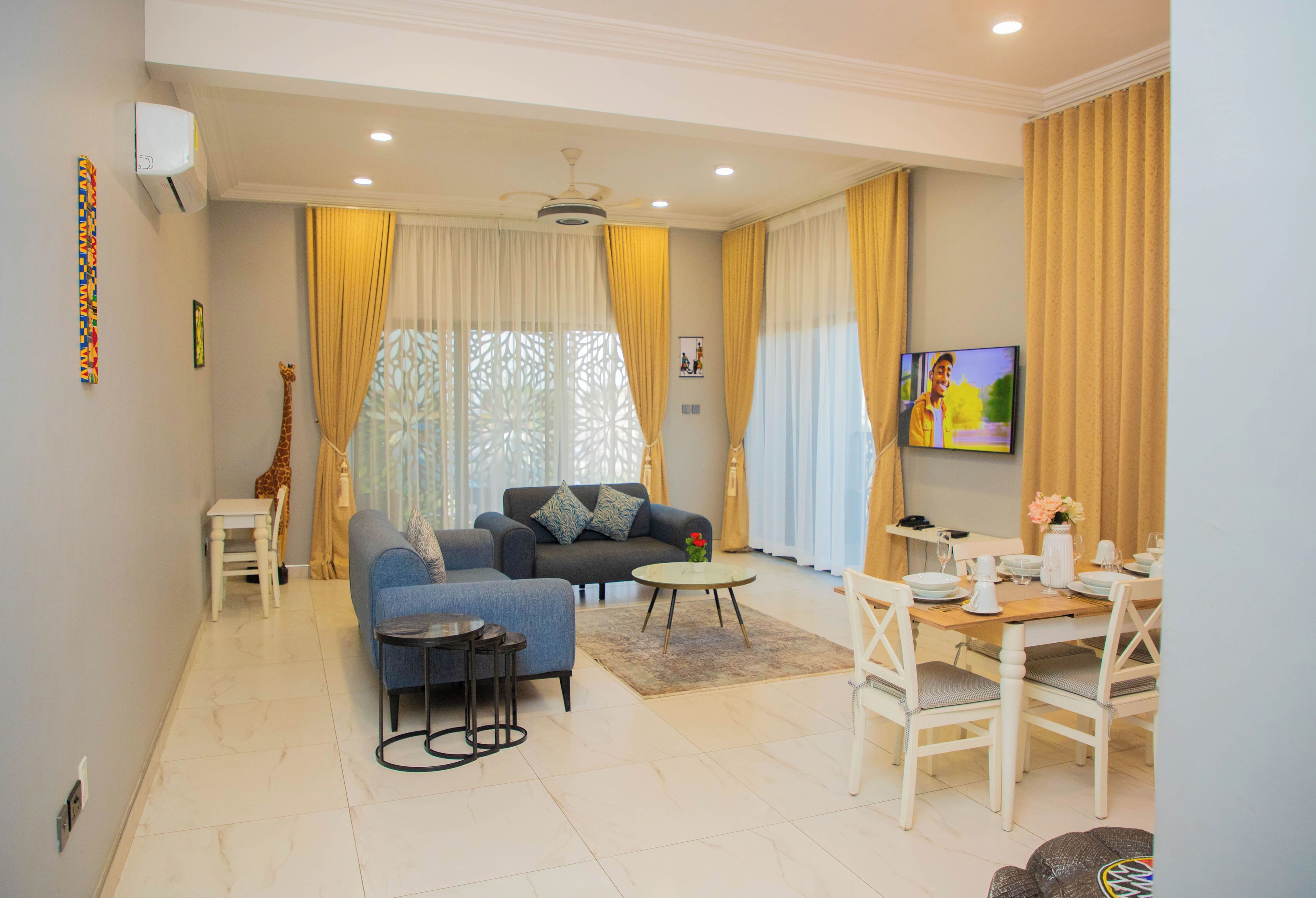 A modern living room with a sofa, coffee table, and dining table.