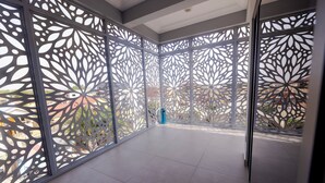A spacious balcony with a modern geometric design, large windows, and a tiled floor. - D'Magnolia Luxury Apartments (Madina)