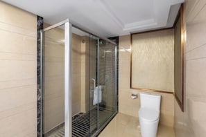 Un baño moderno con cabina de ducha de vidrio, un inodoro blanco y suelo de baldosas de mármol.