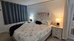 A bedroom with a bed, nightstands, a dresser, and a window with curtains. - Ambassador #224 w/Amazing Beach Front View ~ Pool ~ Hot Tub ~ Pier Park~ Pets Ok (Panama City Beach)