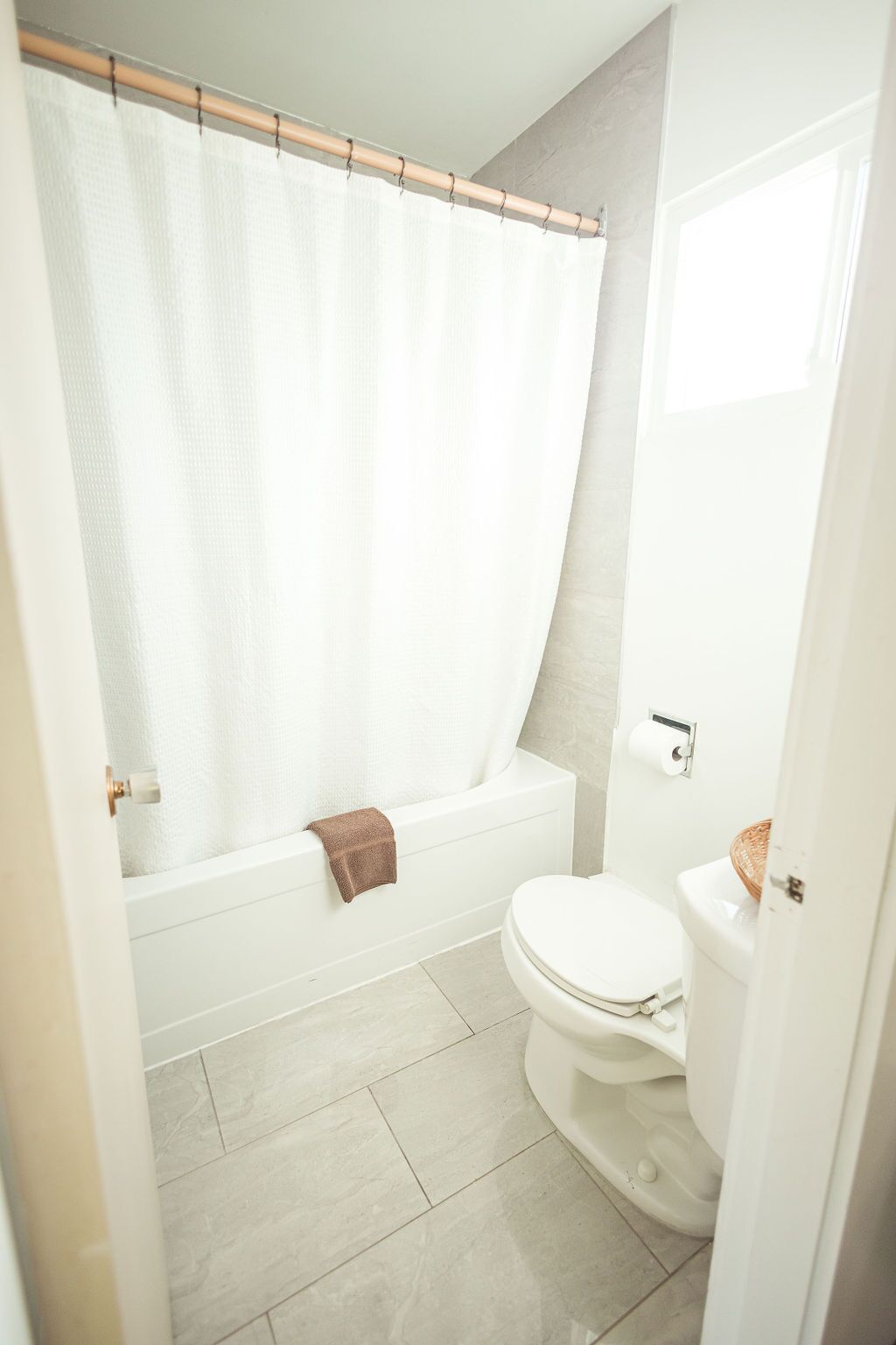 A bathroom with a bathtub, toilet, and a shower curtain.
