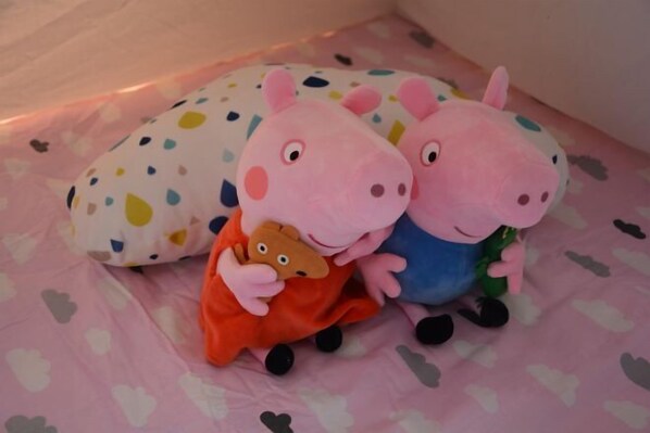Two plush toys on a bed with a polka dot pillow. - Kela Hotel (Fenyi)