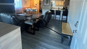 Ein modernes Wohnzimmer mit einer Couch, einem Couchtisch und einem Essbereich mit Stühlen und einem Tisch.