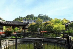 Un jardín chino tradicional con un puente de piedra, un estanque y arquitectura de estilo pagoda.