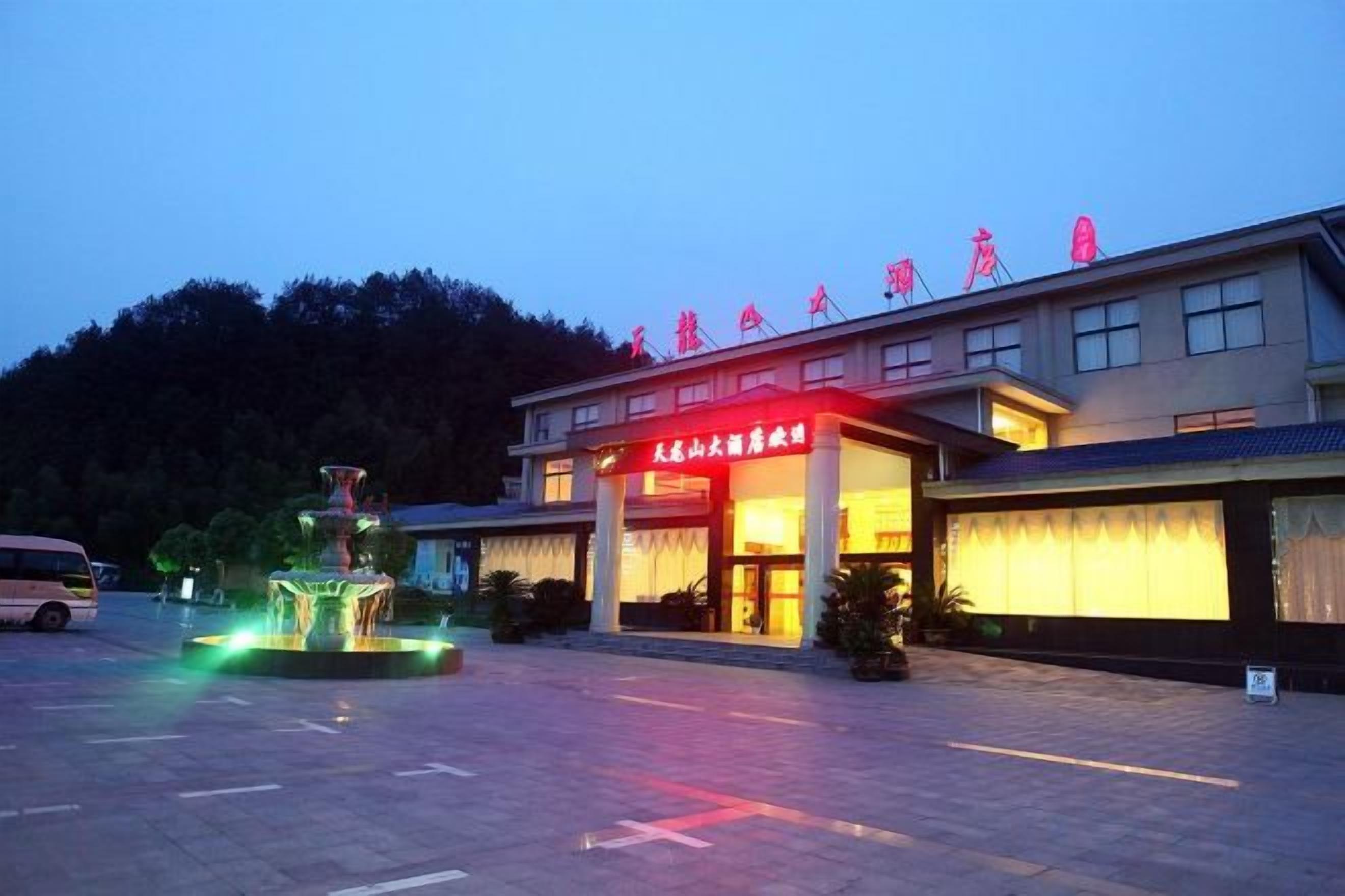A hotel with a prominent entrance and a fountain in the courtyard.
