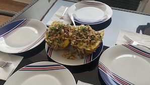 Een eettafel met borden, bestek en een maaltijd.