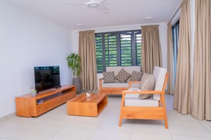 Deluxe 2 Bedrooms Apartment, Garden view | Living area | 50-inch Smart TV with cable channels, Netflix, streaming services