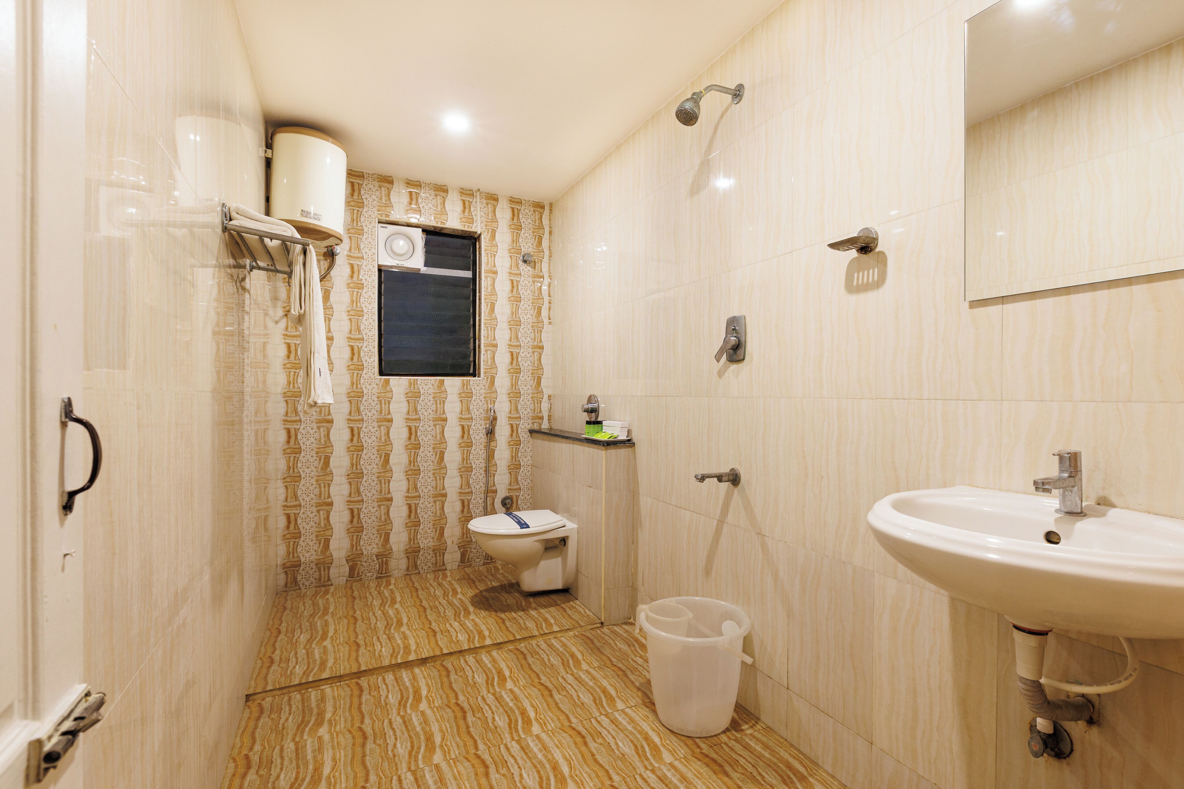 Une salle de bain avec des toilettes, un lavabo et une douche.