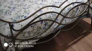 A bed with a floral bedspread, a window with blinds, and a wall-mounted light fixture. - Comfortable 3BD home -5 mins to Scarborough Town center (Toronto)
