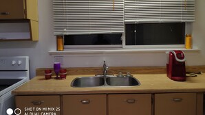 A kitchen with a sink, a stove, and a window with blinds. - Comfortable 3BD home -5 mins to Scarborough Town center (Toronto)