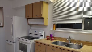 A kitchen with a white refrigerator, stove, and oven, wooden cabinets, a double sink, and a window with blinds. - Comfortable 3BD home -5 mins to Scarborough Town center (Toronto)