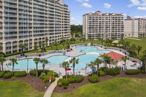 A hotel complex with multiple high-rise buildings, a central swimming pool, and surrounding landscaped areas.
