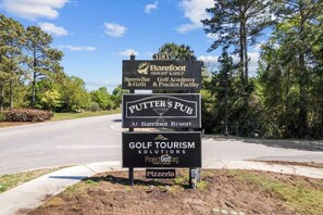 A sign for Barefoot Resort & Golf, including a sports bar, golf academy, and practice facility.