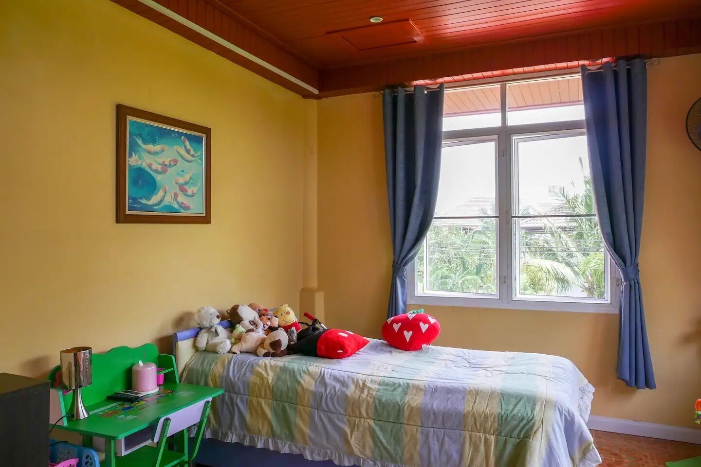 Une chambre avec un lit, un bureau et une fenêtre avec des rideaux.