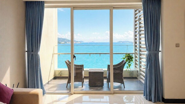 Un balcón con vistas al mar, una silla, una mesita y un sofá.