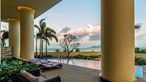 Zona de piscina con sillones de descanso y vistas al mar.