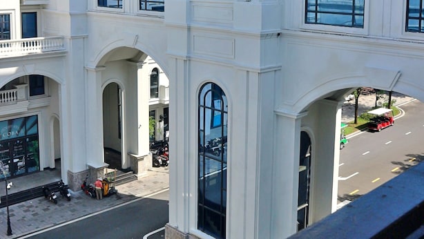 Een meerhoog gebouw met een centrale toren, grote boogvensters en een balkon.