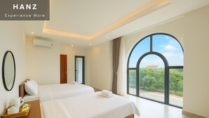 Een hotelkamer met twee bedden, een groot raam met uitzicht en een ontbijtplateau op het nachtkastje.