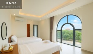 Een hotelkamer met twee bedden, een groot raam met uitzicht en een ontbijtplateau op het nachtkastje.
