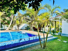 Una piscina al aire libre, sombrillas, tumbonas