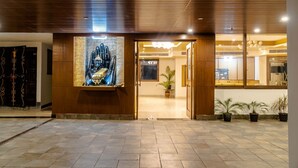 A hotel entrance with a wooden facade, a large Buddha statue, and a reception area visible through the doorway. - The Aryan Hotel Gangtok (Gangtok)