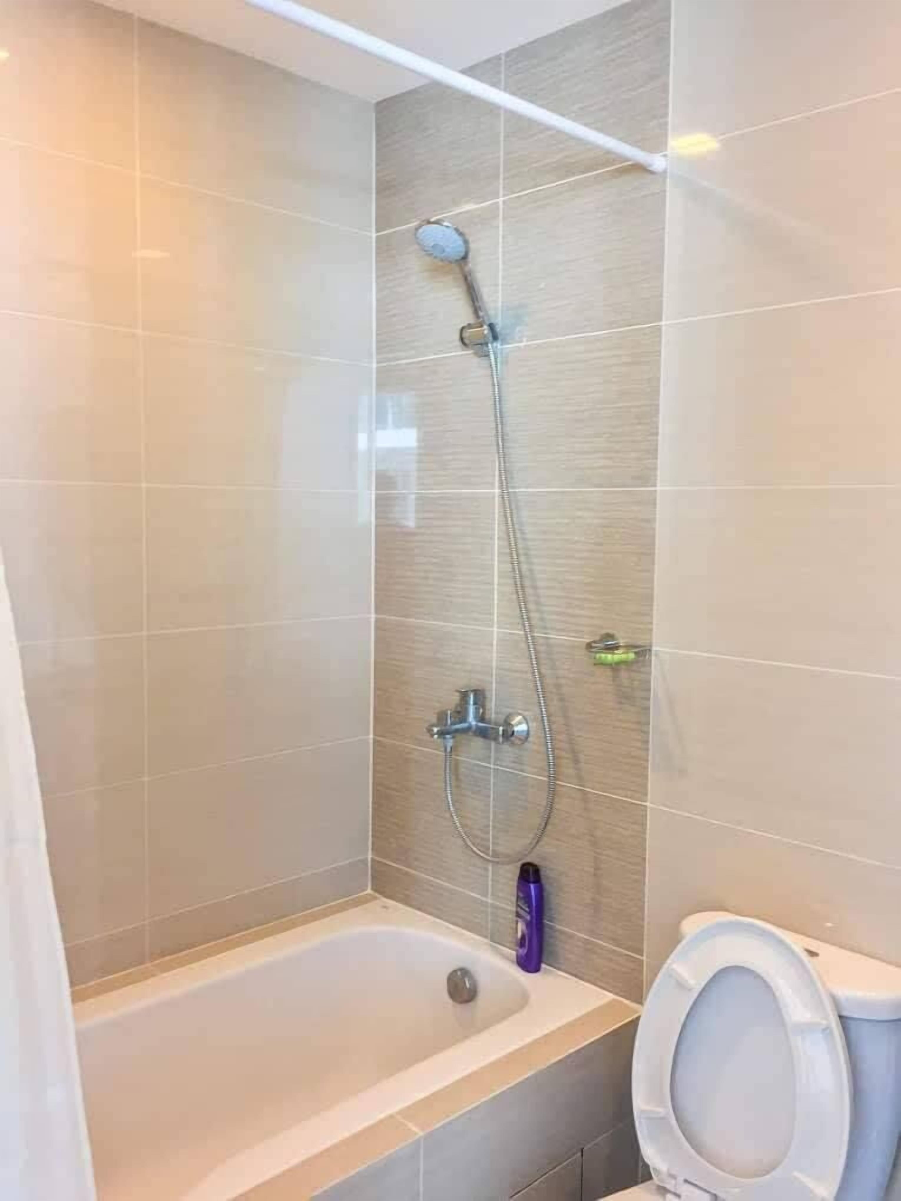 A bathroom with a shower, a bathtub, and a toilet.