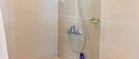 A bathroom with a shower, a bathtub, and a toilet.