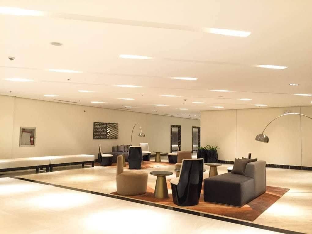 Un hall d’entrée spacieux avec un long banc, plusieurs canapés et une table basse.