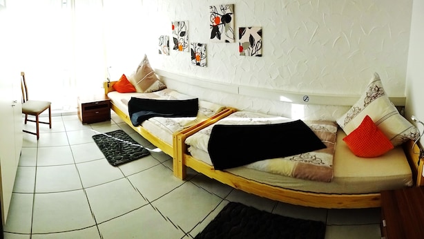 A room with a sofa, a chair, and a bed. There are wall decorations and a window. - 80sqm two-room apartment - Wipfelder Montuerzimmer (Wipfeld)