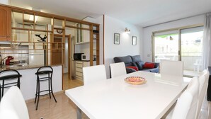 Eine moderne Küche mit Essbereich, einer Couch und Blick ins Freie.