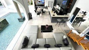 A modern interior with a pool, a dining area, and a kitchen.