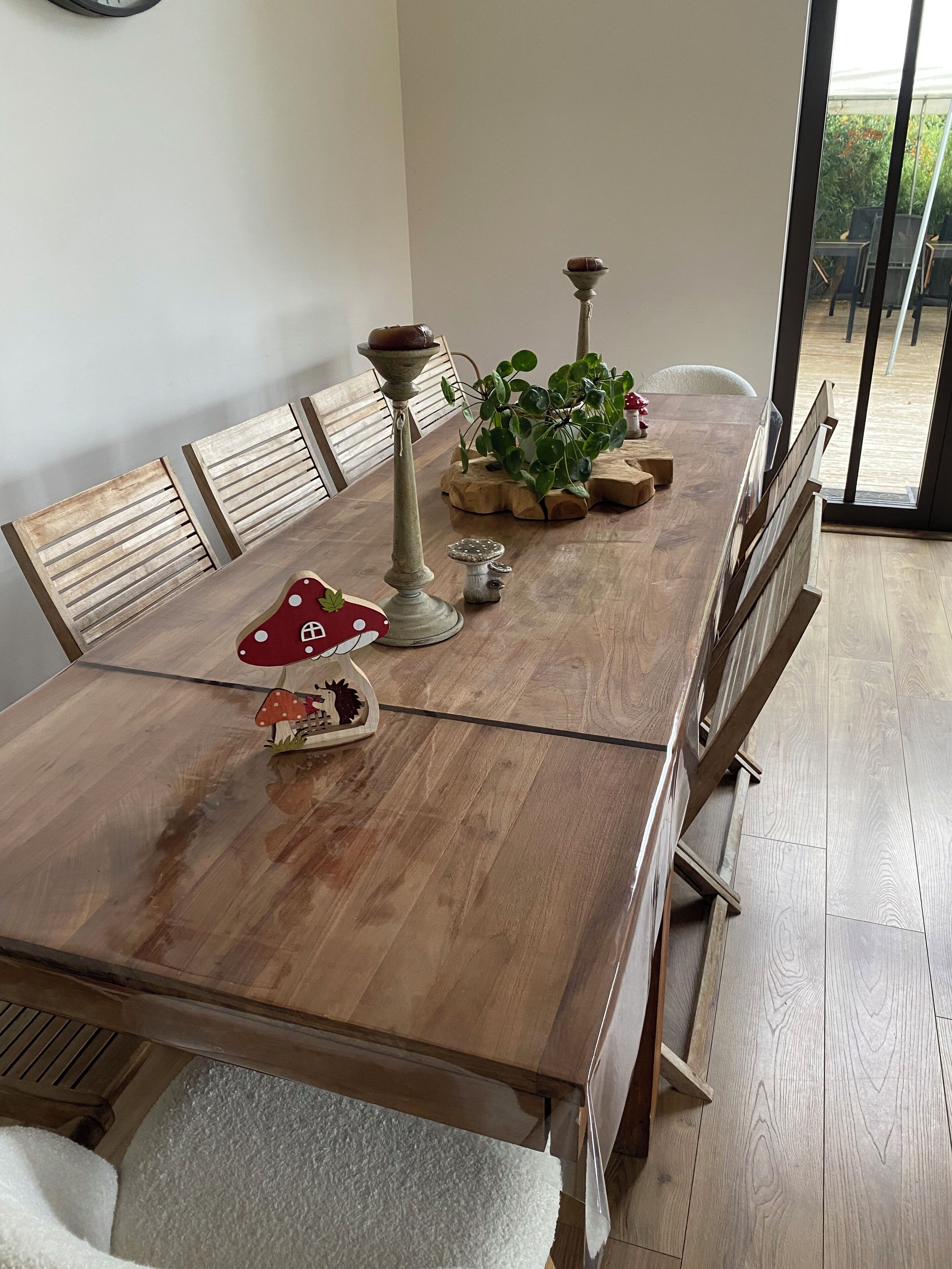 A dining table with wooden chairs, a potted plant, and a decorative mushroom centerpiece.