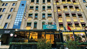 A historic building with a large sign for the Essam Deluxe Hotel. - Essam Deluxe Hotel (Baku)