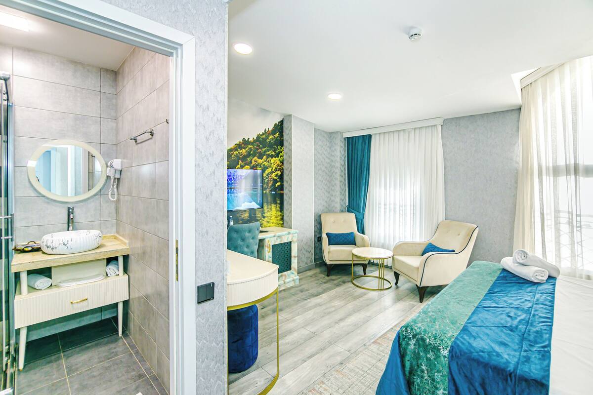 A modern bathroom with a shower, a sink with a round mirror, and a vanity with drawers.