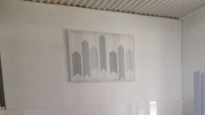 Uma cozinha moderna com armários brancos, bancada preta, pia de aço inoxidável, chaleira e micro-ondas.
