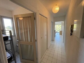 A hallway with a door leading to a balcony, a staircase, and a room with a bed. - Studio cabin for 4, near the beach, pets allowed - Saint-Cyprien (Saint-Cyprien)