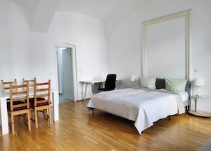 A bedroom with a bed, a desk, and two chairs. - Lovely Modern Historical 1-bedroom (Vienna)
