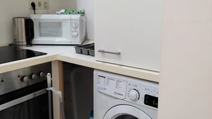 A compact kitchen with a microwave, toaster, and oven. - Lovely Modern Historical 1-bedroom (Vienna)