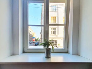 Enjoy the view of the city from this cozy corner window with a potted plant.
