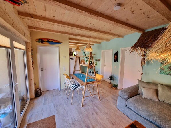 Une pièce chaleureuse avec un plafond en bois, un lit superposé, un canapé et une table à manger.