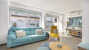 A living room with a light blue sofa, a yellow armchair, and a round wooden table. - Spanish villa with private pool , only 5 minutes from the beach! (San Pedro de Alcantara)