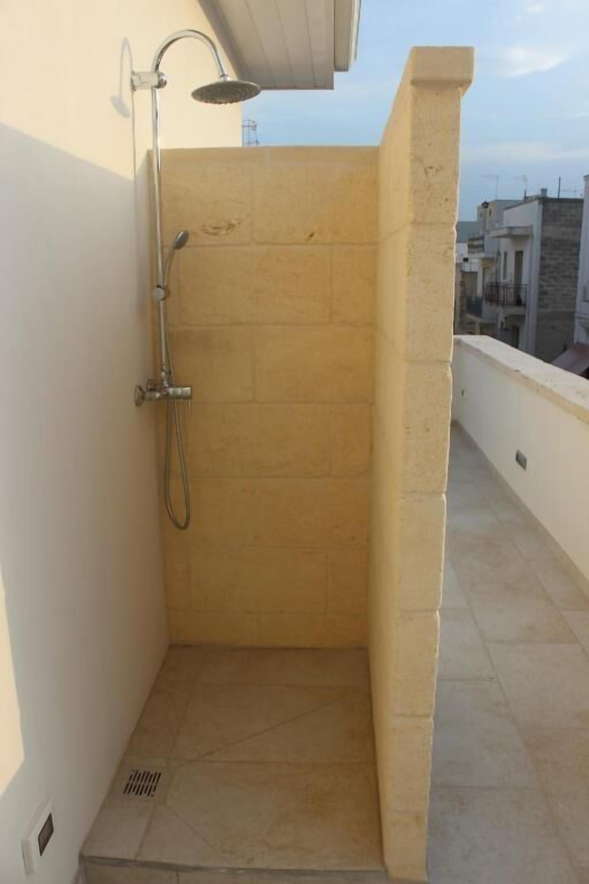 A small, enclosed shower area with a tiled floor and a showerhead.